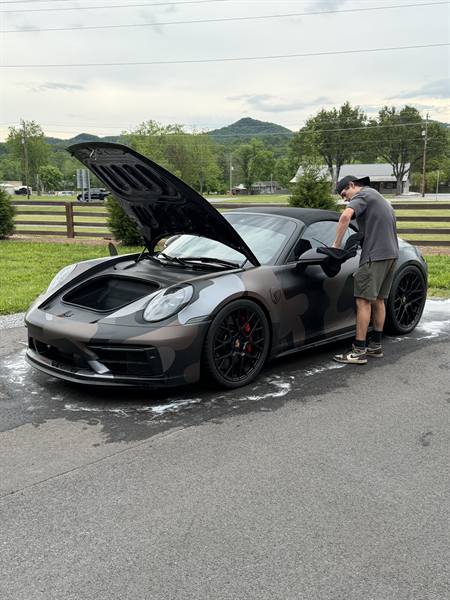 Knox Precision Detail hand washing a camo Porsche 911 in a Knoxville driveway