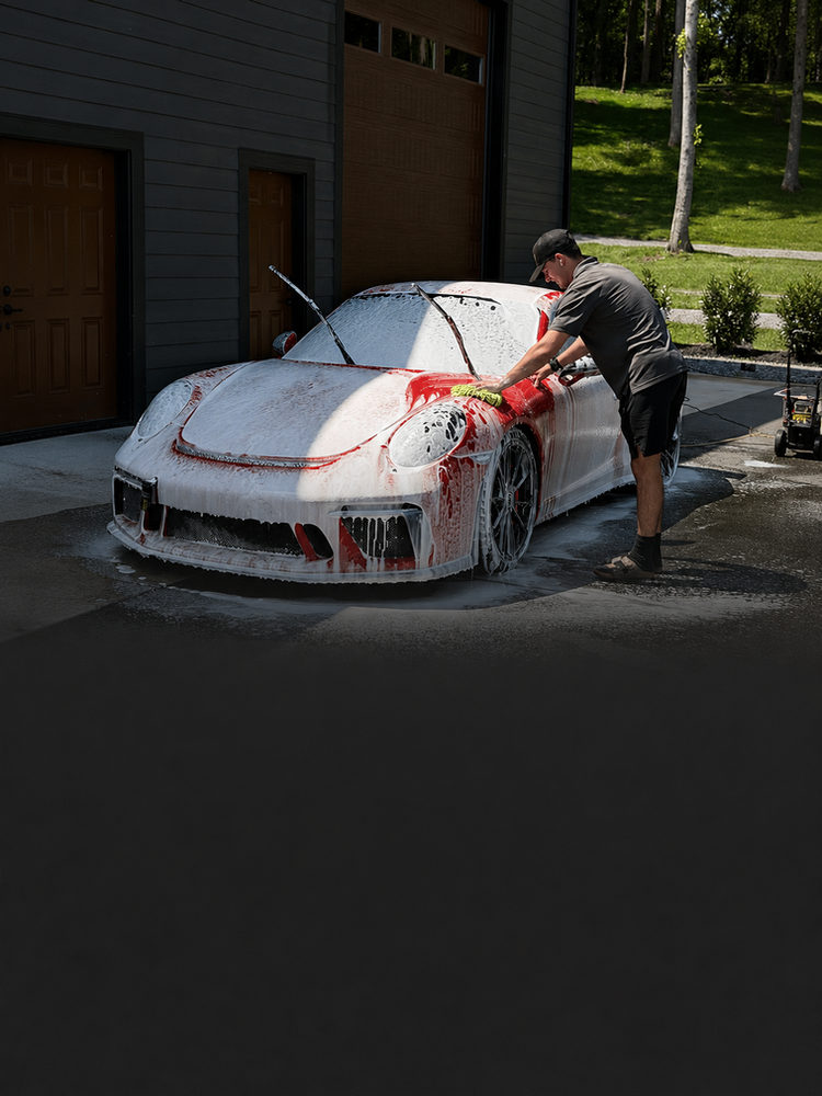 Detailer foam washing a red sports car in Knoxville