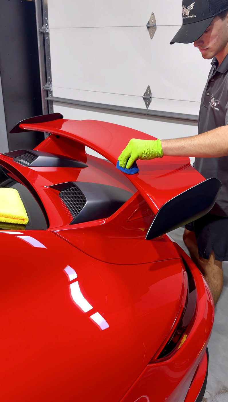 Applying ceramic coating to a red Porsche wing